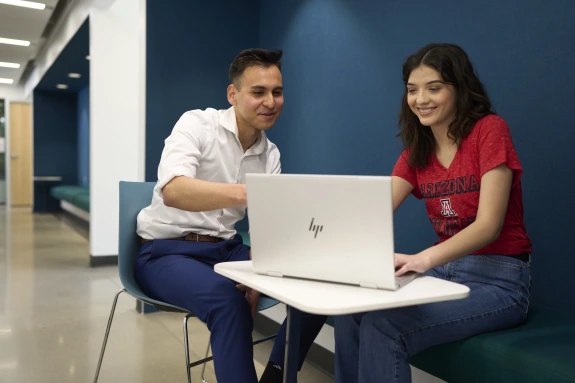 student and advisor looking at a laptop