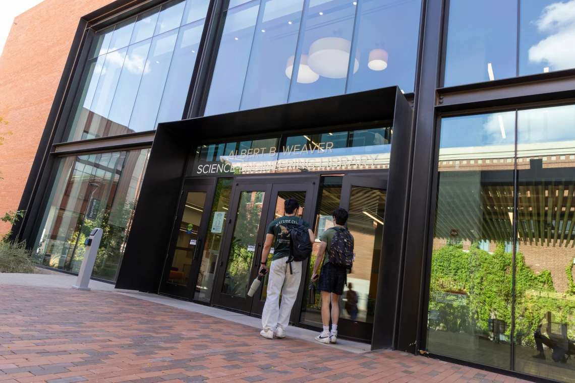 two students walking into weaver library 