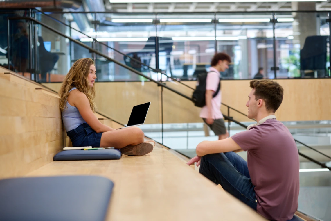 students sitting on staircase talking